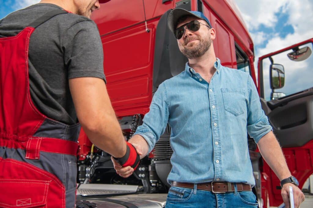 Happy and Satisfied Truck Driver Shaking His Mechanics Hand